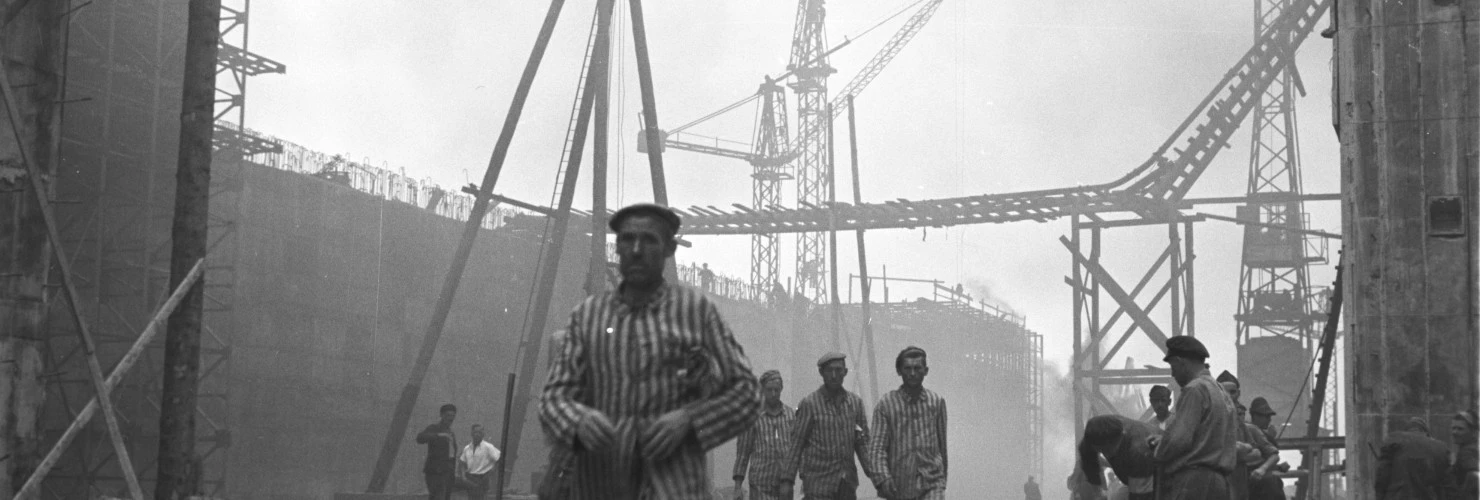 Poster von dem Tag des Gedenkens an die Opfer des Nationalsozialismus. Ein Foto geschossen von Johann Seubert im Auftrag der Nationalsozialisten. Es zeigt gehende Zwangsarbeiter auf der Bunkerbaustelle "Valentin" in Bremen Farge  
