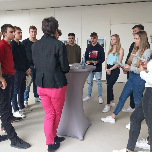 Eine Gruppe von Personen, die um einen Tisch herum stehen.  