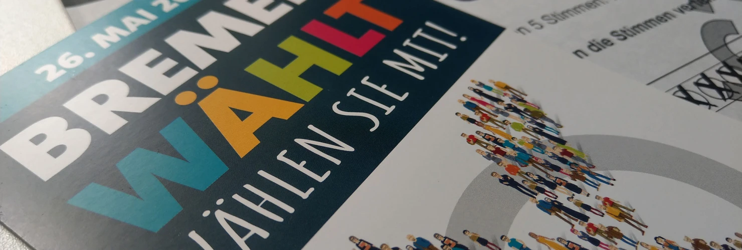 Das Bild zeigt einen Flyer für die Wahlen in Bremen am 26. Mai 2019. Auf dem Blatt steht der Slogan "BREMEN WÄHLT. Wählen Sie mit!", neben weiteren Textelementen über die Wahl. Grafisch hervorgehoben ist eine Abbildung von vielen kleinen, stilisierten Menschen, die sich an einer Wahlurne anstellen.  
