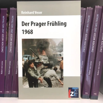 Das Buchcover von "Der Prager Frühling 1968" von Reinhard Veser, mit dem Hintergrund der Bücher.  