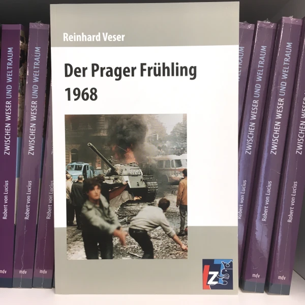 Buchcover von " Der Prager Frühling 1968" von Reinhard Veser, mit dem Hintergrund der Bücher.  
