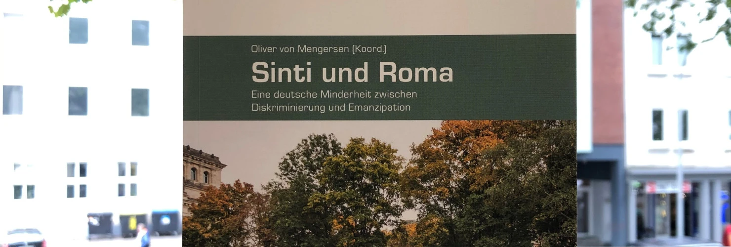Buchcover von "Sinti und Roma"-Eine deutsche Minderheit zwischen Diskriminierung und Emanzipation, von Oliver von Mengersen, mit dem Hintergrund eines Baumes.  