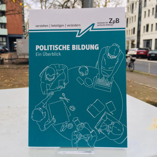 Ein Bild des Buches: "Politische Bildung" ein Überblick, mit dem Hintergrund von Gebäuden.  