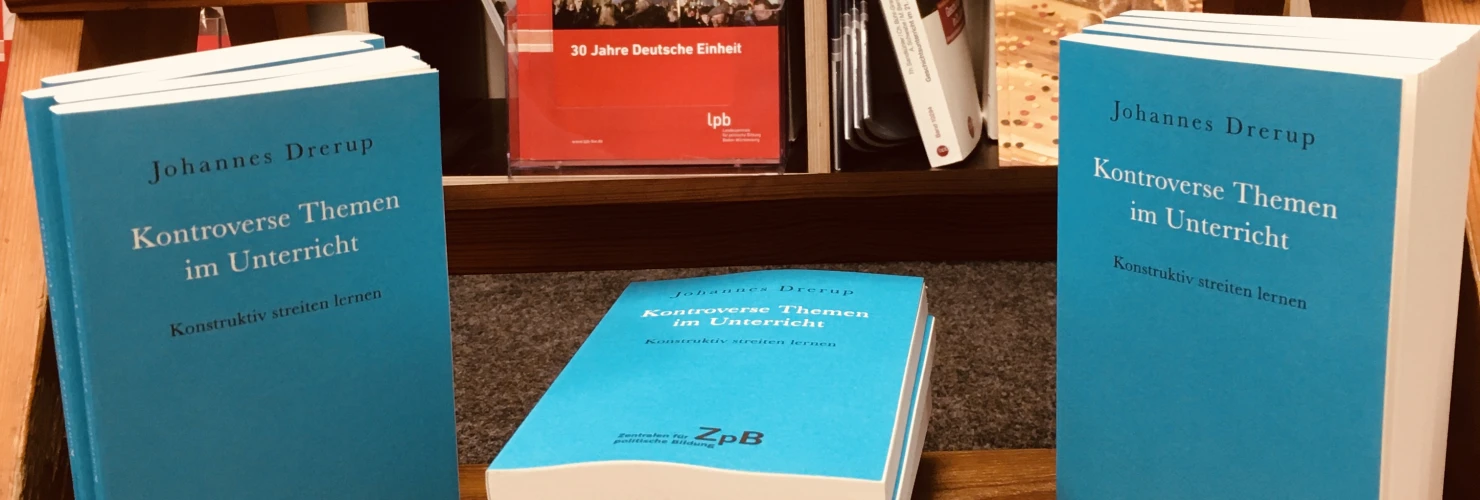 Ein Bild der Bücher: " Kontroverse Themen im Unterricht. Konstruktiv streiten lernen" von Johannes Drerup mit einem Hintergrund aus Bücherregalen.   