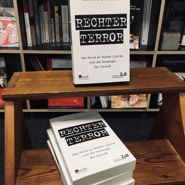 Ein Bild des Buches "Rechter Terror. Der Mord an Walter Lübcke und die Strategie der Gewalt" von Martin Steinhagen mit dem Hintergrund der Bücherregale  