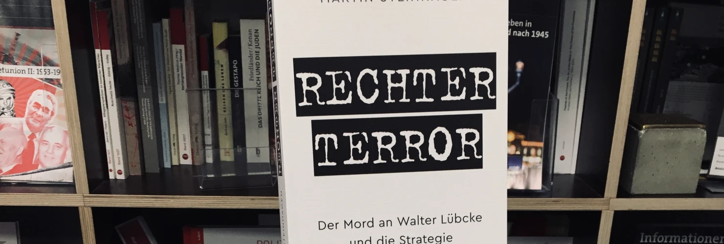 Ein Bild des Buches "Rechter Terror. Der Mord an Walter Lübcke und die Strategie der Gewalt" von Martin Steinhagen mit dem Hintergrund der Bücherregale