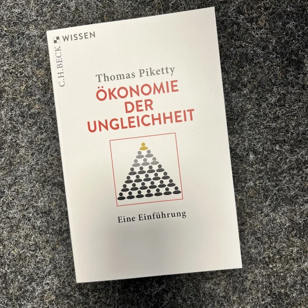Das Buchcover von "Ökonomie der Ungleichheit. EINE EINFÜHRUNG." von Thomas Piketty. Darauf abgebildet ist eine gezeichnete Pyramide aus Figuren. Die oberste Figur ist Gold, während alle anderen schwarz sind.  