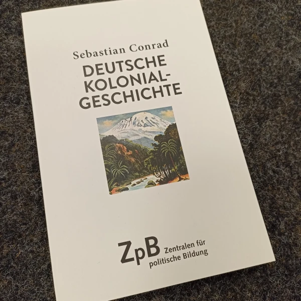 Das Buchcover von "Deutsche Kolonialgeschichte" von Sebastian Conrad zeigt eine kleines Bild von einer malerischen Berglandschaft  