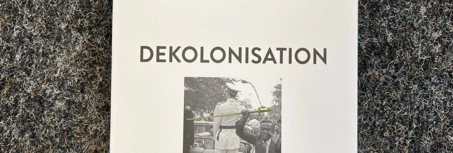Das Bild zeigt das Cover eines Buches mit dem Titel "Dekolonisation" von Jan C. Jansen und Jürgen Osterhammel, verlegt bei zpb. Auf dem Cover ist eine Schwarz-Weiß-Fotografie zu sehen, auf der eine Statue mit einem Tuch verhüllt wird, was symbolisch für das Thema Dekolonisation stehen könnte. Der Hintergrund des Covers ist schlicht weiß, und der Text ist in einer klaren, schwarzen Schrift gehalten.  