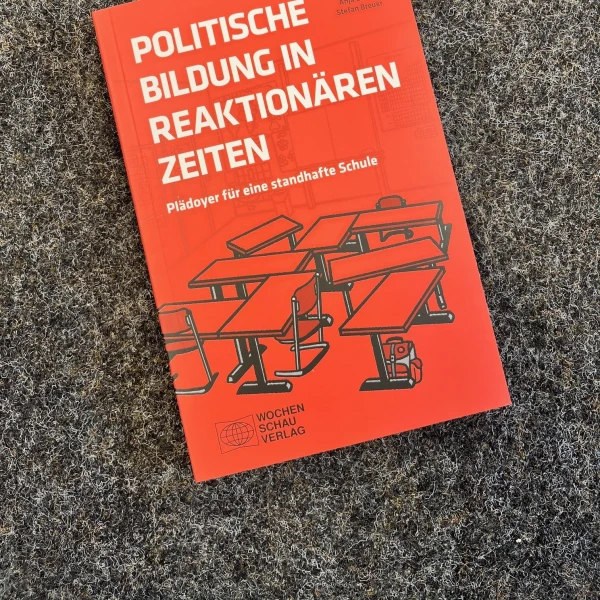 Das Buchcover von "Politische Bildung in reaktionären Zeiten - Plädoyer für eine standhafte Schule" von Rico Behrens, Anja Besand und Stefan Breuer. Es zeigt stilisierte Schultische mit Stühlen.   