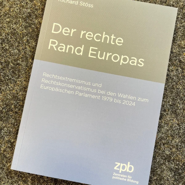 Das Bild zeigt ein Buch, das auf einer grauen steinernen Oberfläche liegt. Auf dem Buchumschlag steht in grauen und schwarzen Buchstaben der Titel "Der rechte Rand Europas" von Richard Stöss, darunter der Untertitel "Rechtsextremismus und Rechtspopulismus bei den Wahlen zum Europäischen Parlament 1979 bis 2024". Das Cover ist schlicht gehalten mit einer klaren, übersichtlichen Textanordnung.  