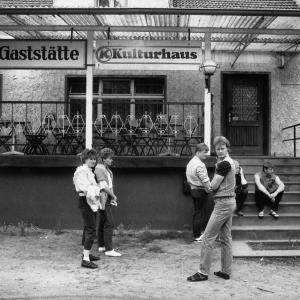 Schwarz-Weiß Foto von jungen Leuten vor einer Gaststätte.