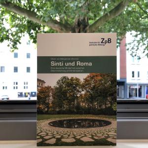 Buchcover von "Sinti und Roma"-Eine deutsche Minderheit zwischen Diskriminierung und Emanzipation, von Oliver von Mengersen, mit dem Hintergrund eines Baumes.