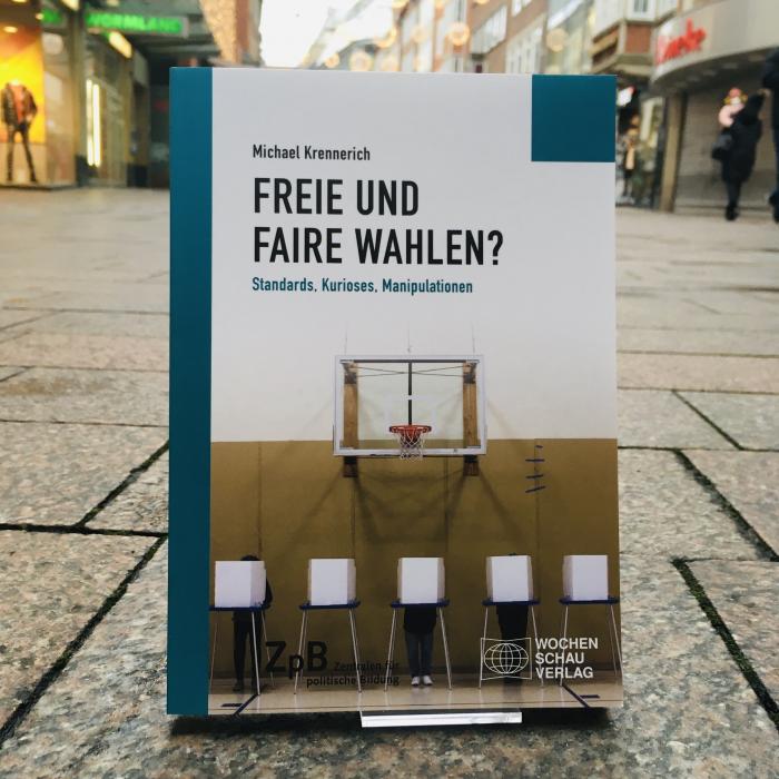Ein Bild des Buches: "Freie und Faire Wahlen?"-Standards, Kurioses, Manipulationen von Michael Krennerich, mit dem Hintergrund einer städtischen Straße.